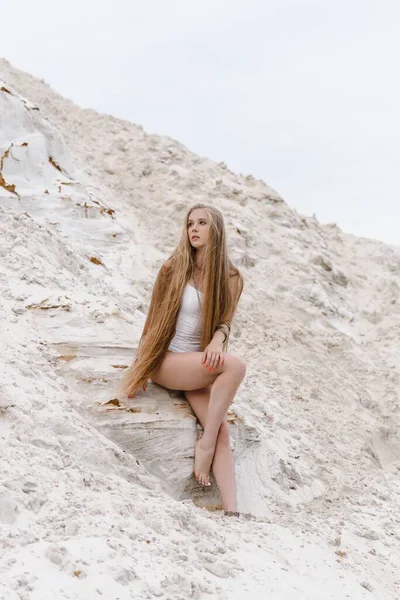 Молода струнка красива струнка сексуальна жінка в білому купальнику на білому піску на пляжі з — стокове фото