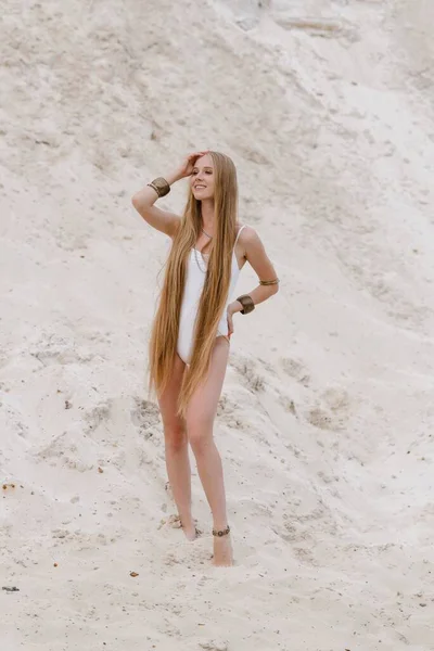 Jong slank mooi slank sexy vrouw in wit badmode bodysuit op wit zand op het strand met — Stockfoto