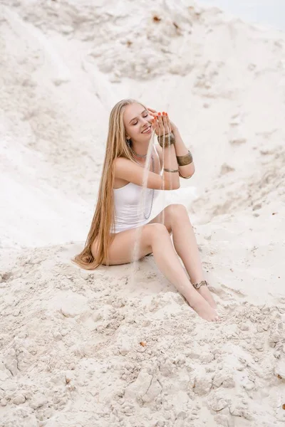 흰 수영복을 입은 젊고 날씬하고 매력적 인 젊은 여성 이 해변에서 흰색 모래 위에서 보디 복을 입고 있다 — 스톡 사진
