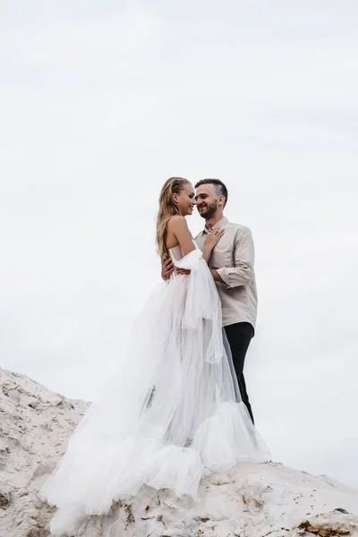 Mooi bruidspaar bruid en bruidegom op trouwdag buiten op oceaan strand. Gelukkig huwelijk Stockfoto