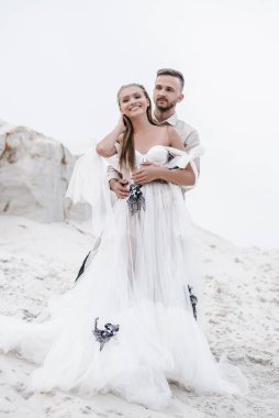 Güzel bir çift gelin ve damat, düğün günü okyanus sahilinde. Mutlu evlilikler.