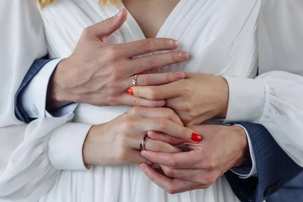 結婚指輪を持つ若者の手。結婚式の日の詳細。コール・フラワーズ。配偶者 — ストック写真