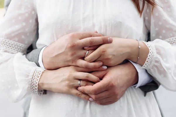 Handen van jonge mensen met trouwringen. trouwdag details. calla bloemen. echtgenoten Stockfoto
