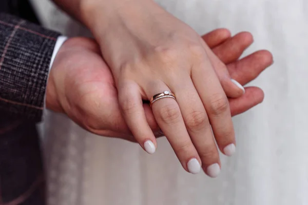 Manos de jóvenes con anillos de boda. detalles del día de la boda. Flores de cala. cónyuges —  Fotos de Stock