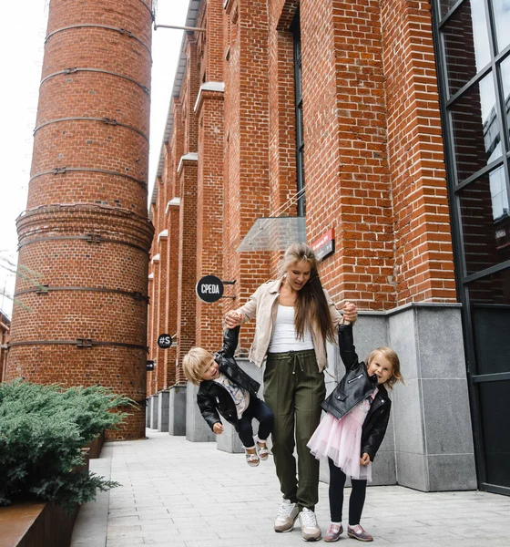 Jeune belle mère aux cheveux longs avec des enfants en promenade dans la rue bonheur joie plaisir maternité — Photo