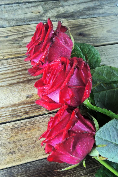 Κόκκινο τριαντάφυλλο σε ξύλινο φόντο — Φωτογραφία Αρχείου