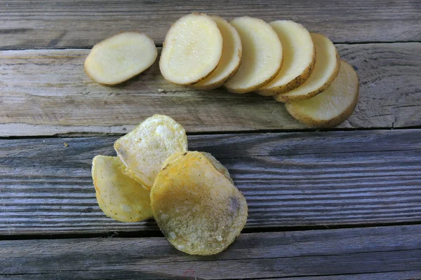 Chips und rohe Kartoffeln — Stockfoto