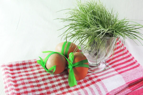 Slepičí vejce a zelené trávy na bílém pozadí — Stock fotografie