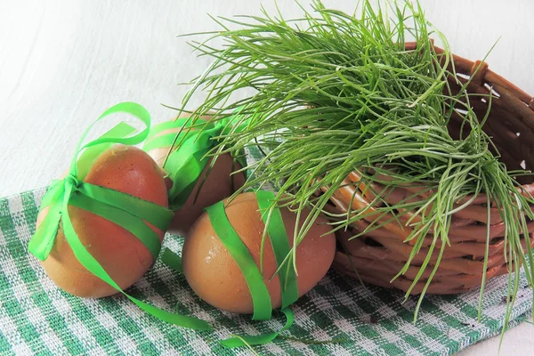 Hönsägg och grönt gräs på vit bakgrund — Stockfoto