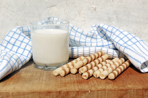 Mléko a vafle rohlíky na dřevěné desce — Stock fotografie