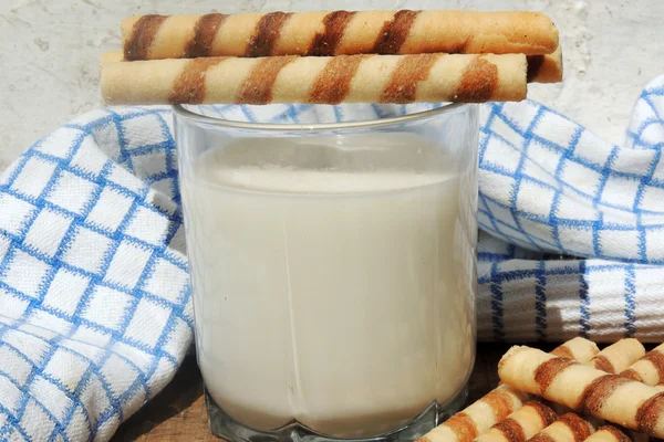 Melk en wafel rolt op houten bord — Stockfoto