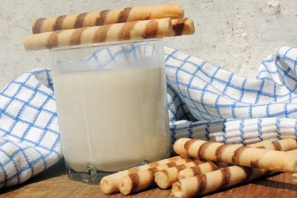 Mléko a vafle rohlíky na dřevěné desce — Stock fotografie