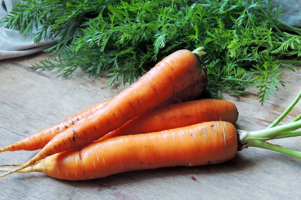 Свежая морковь на деревенском деревянном фоне — стоковое фото