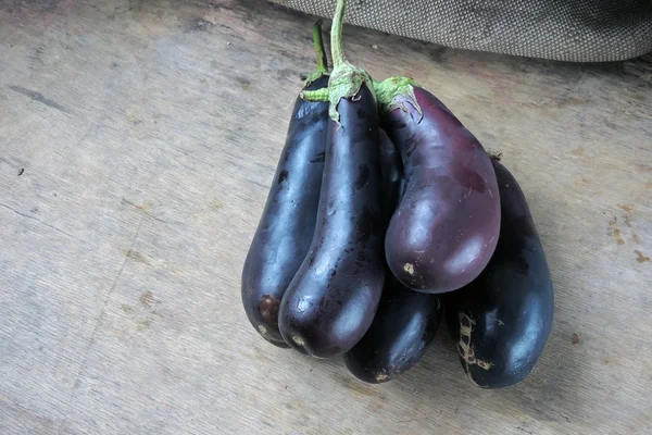 Eine reife Aubergine auf Holzgrund, fünf Stück — Stockfoto