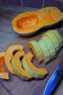 Güveç için hazırlanmış cam bir tavada çiğ portakal kabağı dilimleri. Ahşap antik arkaplan veya masa.