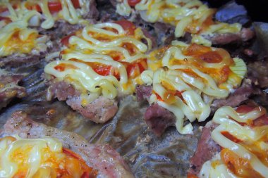 Pişmiş domuz eti, sebze ve peynirli, bir tabakta, beyaz arka planda, izole et