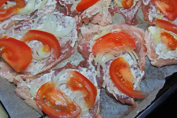 baked pig meat with vegetables and cheese, on a plate, on a white background, isolate