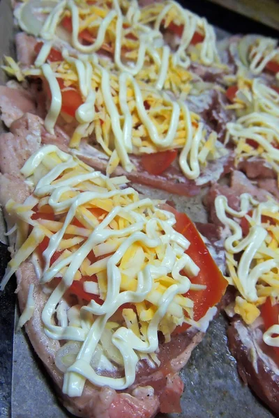 baked pig meat with vegetables and cheese, on a plate, on a white background, isolate