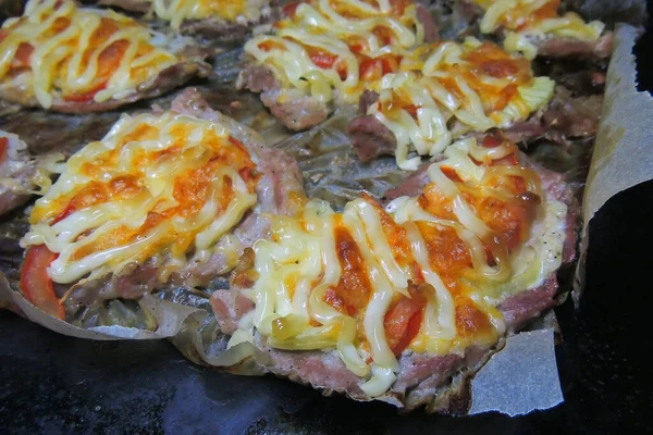 baked pig meat with vegetables and cheese, on a plate, on a white background, isolate