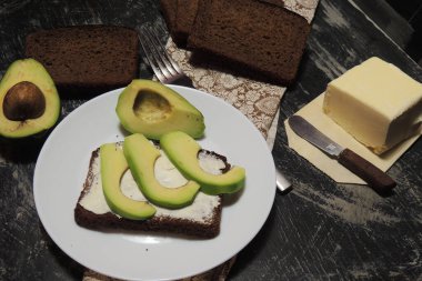 Taze yeşil avokado, yumurta ve pırasalı sandviç.