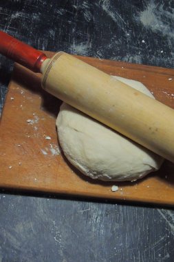 Taş bir yüzeyde merdane ve un ile Hamur