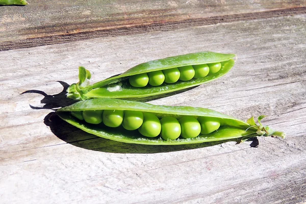 Guisantes sobre fondo de madera —  Fotos de Stock