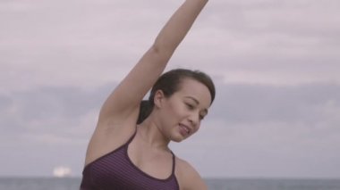 Bulutlu hava plajda çalışan genç kadın. Germe. Fitness. Ağır çekim