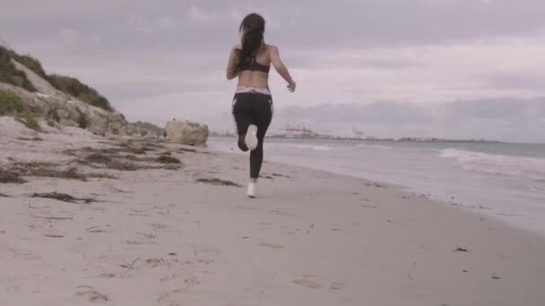 Giovane donna sportiva in forma correre sulla spiaggia. Super lenti colpi stabilizzatore . — Video Stock