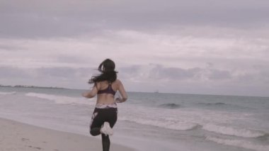 Genç plajda çalışan spor kadın yerleştirmek. Süper ağır çekim sabitleyici çekim.