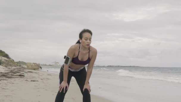 Giovane donna sportiva in forma si riposa dopo un intenso allenamento sulla spiaggia. Super lenti colpi stabilizzatore . — Video Stock