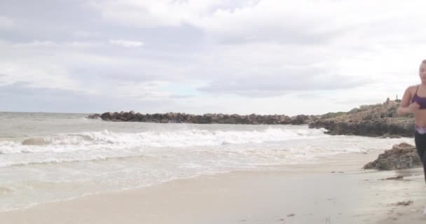 Jovem mulher esportiva ajuste correndo na praia. tiro estabilizador de câmera lenta 4k . — Vídeo de Stock