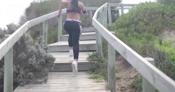 Young fit sports woman jogging on steps. Super slow motion stabilizer shots. — Stock Video