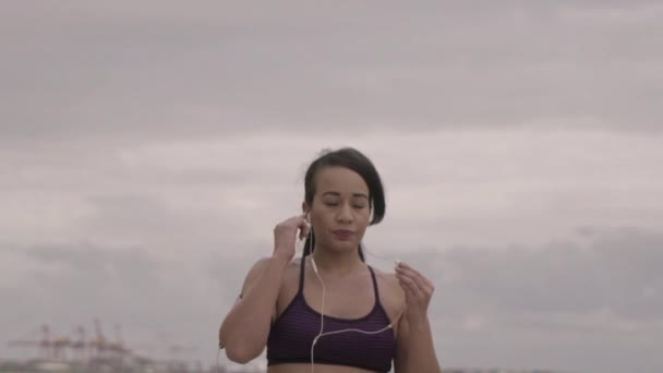 Mladá žena, příprava na běhání na pláži v oblačném počasí. Fitness. Zpomalený pohyb