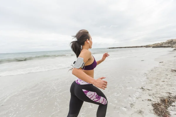 Corredor femenino corriendo durante el entrenamiento al aire libre en la playa — Foto de Stock
