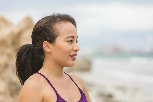 Portret młodej kobiety sportowej stojącej na plaży uśmiechnięty — Zdjęcie stockowe