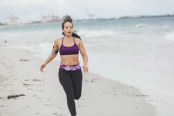 Fitness Woman finishing work out by the Ocean at cloudy winter day — Stock Photo, Image