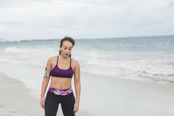 Fitness Woman finishing work out by the Ocean at cloudy winter day — Stock Photo, Image