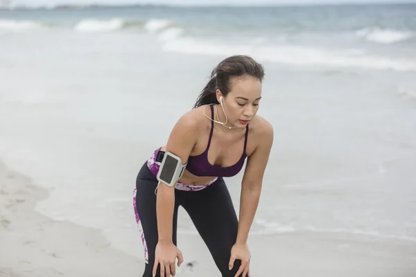 Fitness Femme se reposant après le travail sur la plage à wint nuageux — Photo