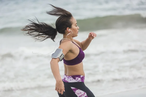 Giovane corridore donna che fa jogging sulla spiaggia. Bella vestibilità mista ra — Foto Stock