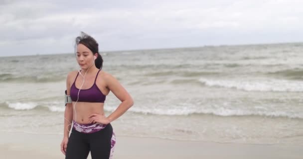 Genç kadın bulutlu hava, sahilde koşu sonra dinlenme. Fitness. Ağır çekim — Stok video