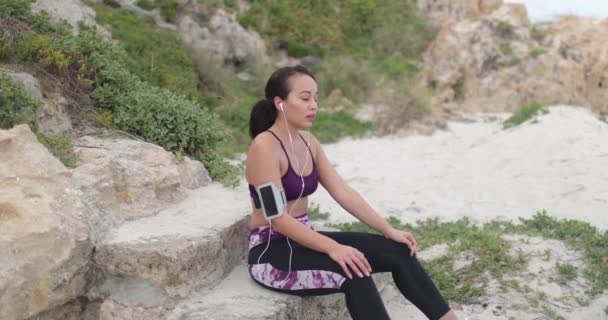 Young passen sport vrouw rust na training op het strand — Stockvideo