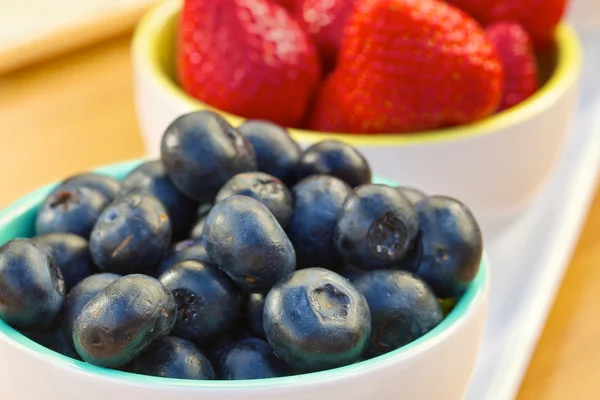 Blueberry and strawberry in white cans — Stock Photo, Image