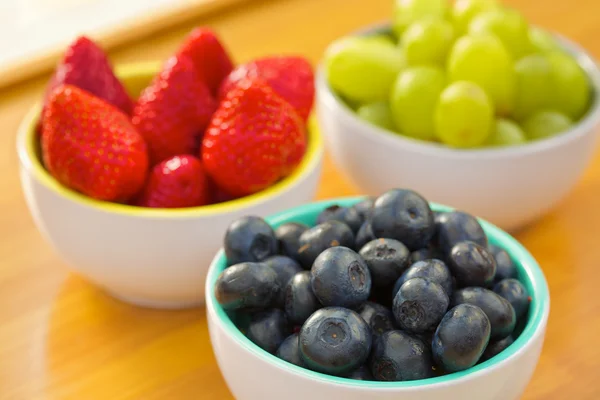 Blueberries, strawberries and grapes in cans — Stock Photo, Image