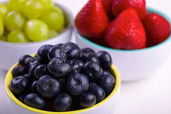 Blueberries, strawberries and grapes in cans — Stock Photo, Image