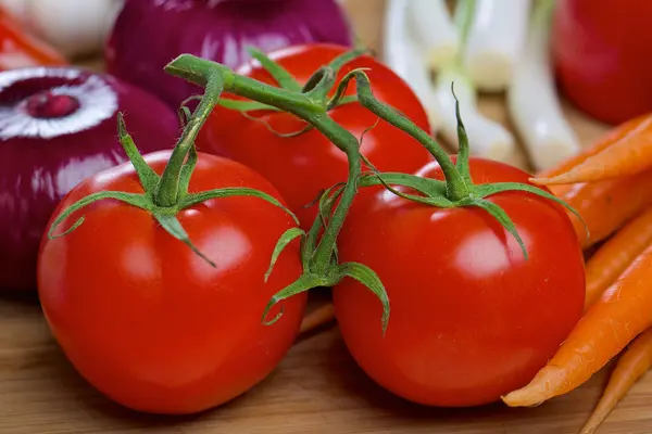 Tomates e outros verduras em uma mesa — Fotografia de Stock