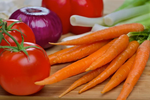 Möhren und Tomaten auf einem Holztisch — Stockfoto