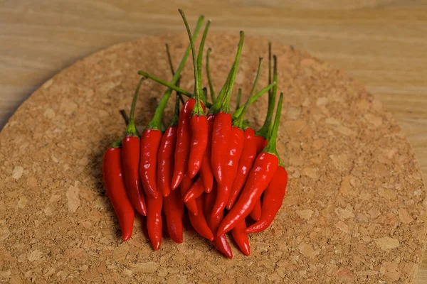 Pimentas vermelhas de pimenta quente em uma mesa de madeira — Fotografia de Stock