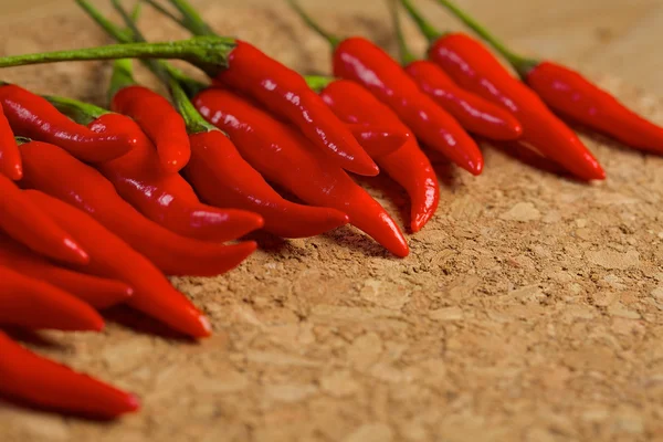 Pimientos rojos picantes en una mesa de madera — Foto de Stock