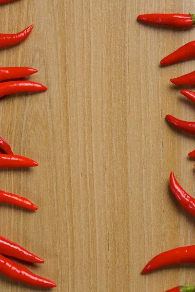 Pimientos rojos picantes en una mesa de madera — Foto de Stock