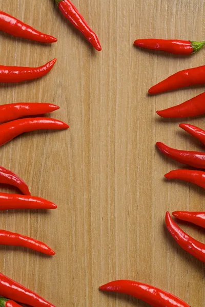Pimentas vermelhas de pimenta quente em uma mesa de madeira — Fotografia de Stock